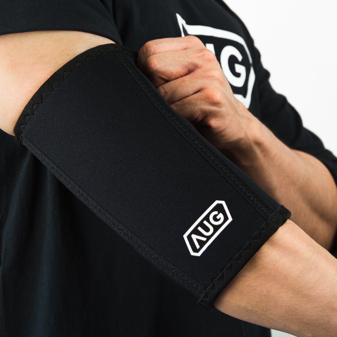 Strength athlete wearing Augments Elbow Sleeves for support and rebound during heavy press.