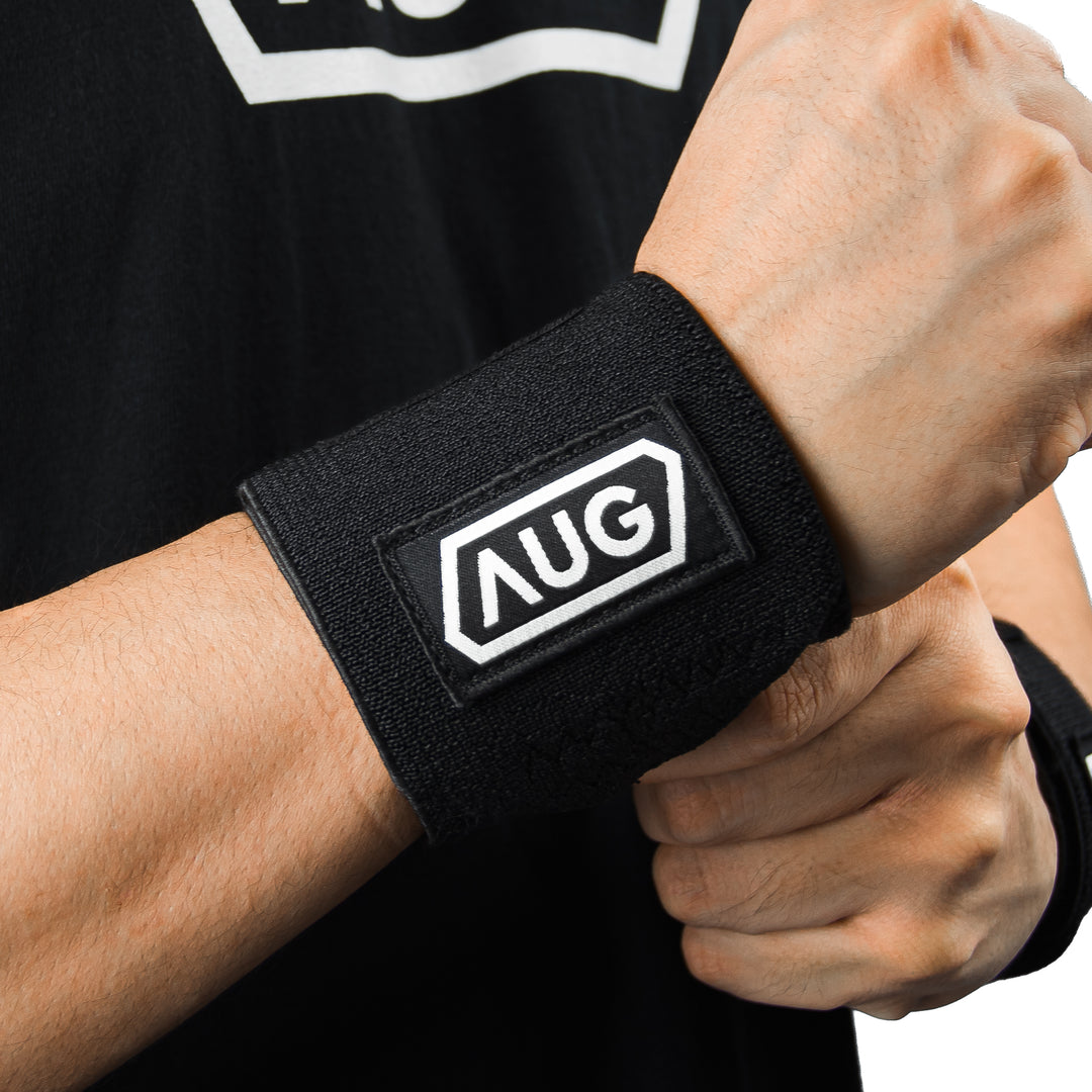 Athlete wearing wrist wraps for heavy press for grip stability and wrist injury prevention for powerlifting competitions.
